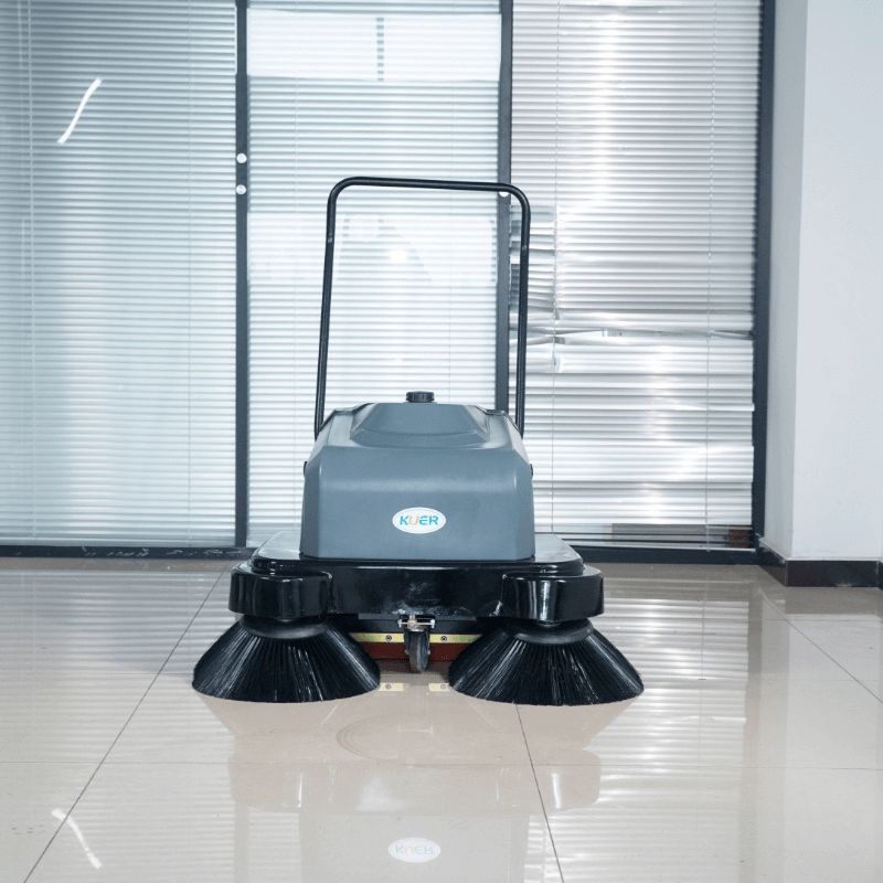 Walk behind floor sweeper cleaning an industrial factory floor and parking lot